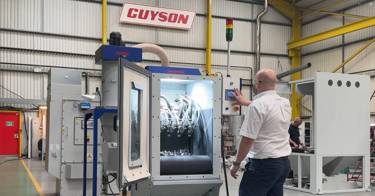 Endless belt blast machine for surface finishing small metal components